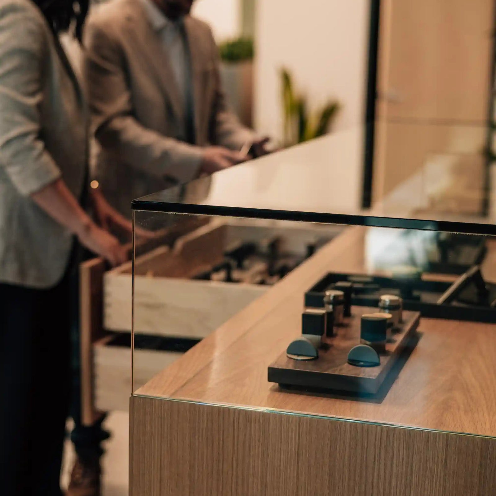 Two people looking a display case for door hardware